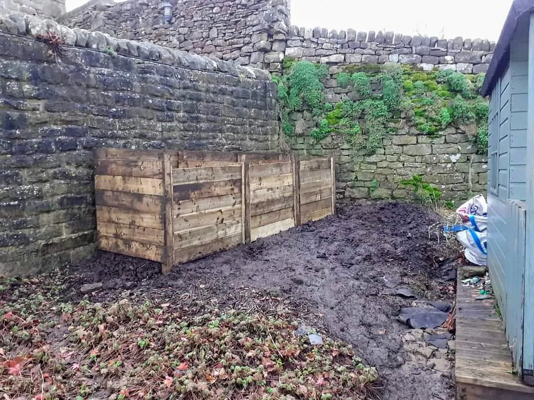 A pile of dirt next to a building.